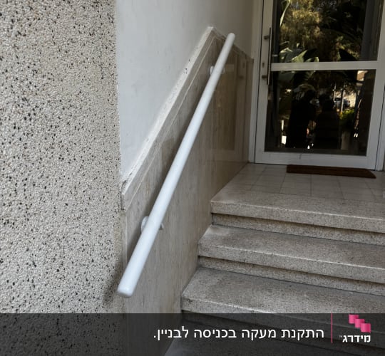 מעקה לבן על גרם מדרגות ליד דלת זכוכית